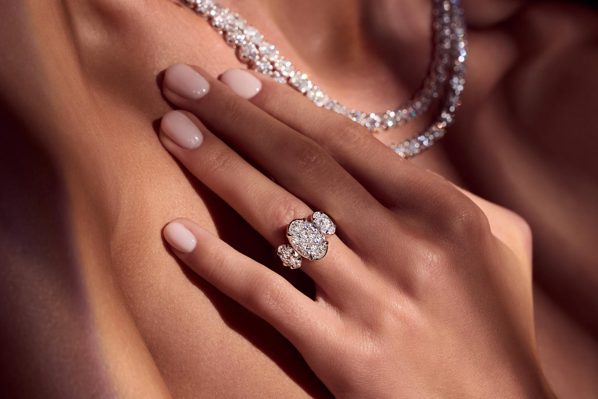 Diamond tennis necklace and a three-stone ring, worn