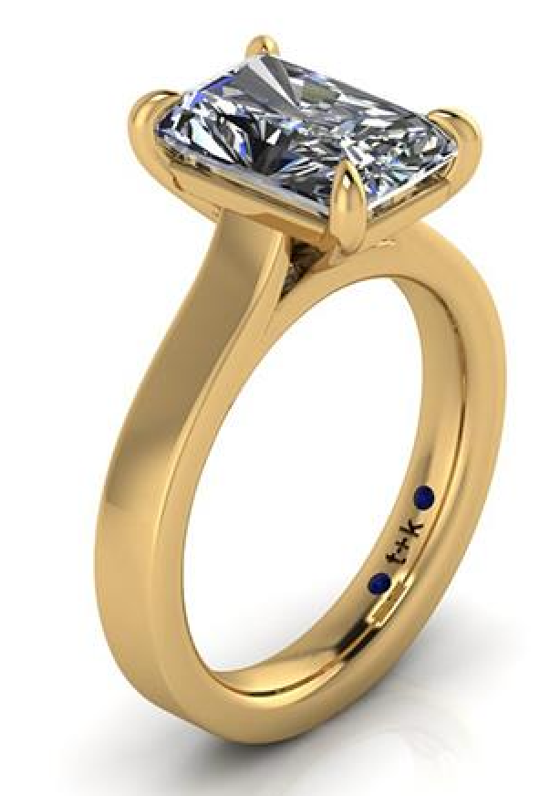 Elegant lab-grown diamond engagement ring in yellow gold with blue sapphire accents, ethical and sustainable choice