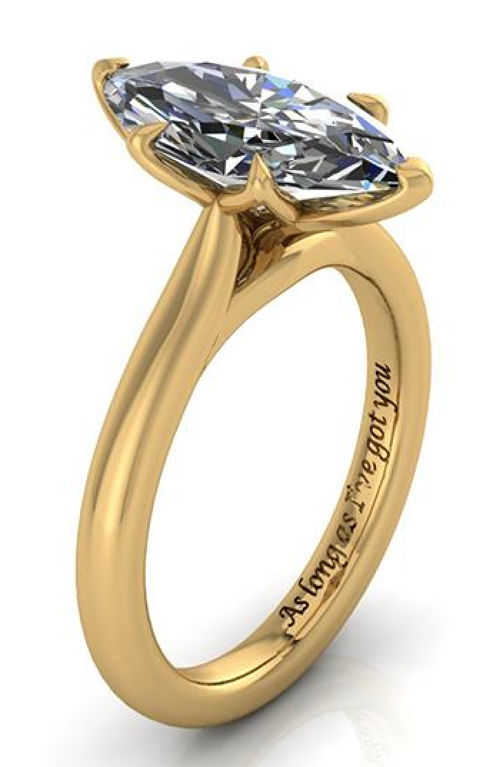 Lab-grown diamond engagement ring in yellow gold with engraved band, featuring a marquise-cut stone and ethical design.