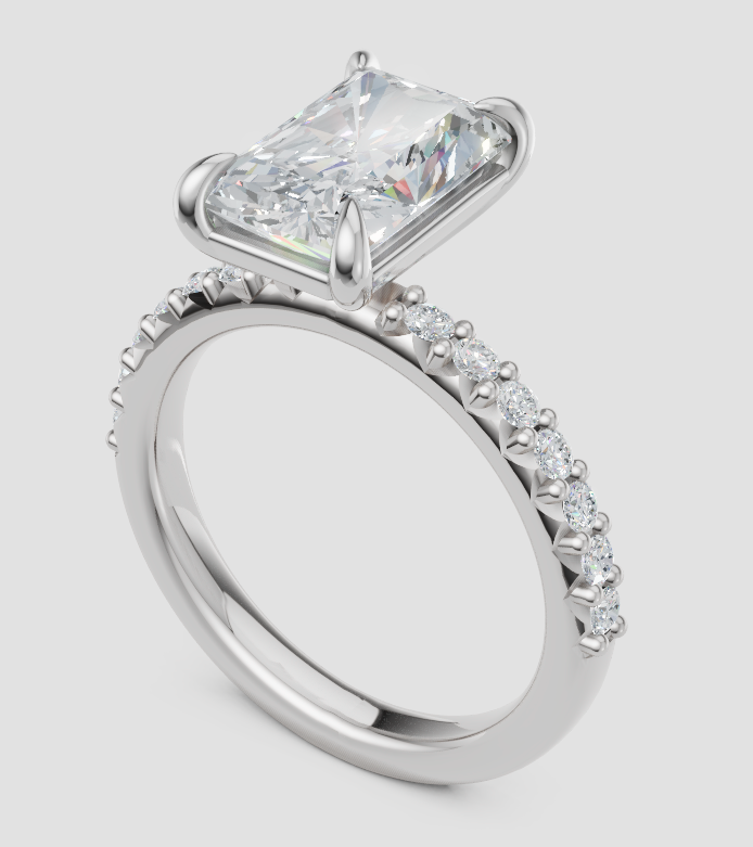 A silver-toned diamond ring featuring a rectangular princess-cut center stone and a pavé-set diamond band, shown on a light gray background.
