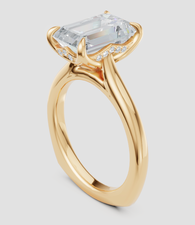 A yellow gold engagement ring featuring a large rectangular emerald-cut clear center stone in a prong setting, accented by small pavé diamonds along the band, shown on a light gray background.