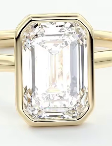 Gold ring with a large emerald-cut diamond on a white background